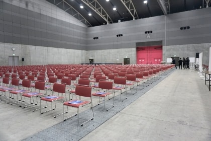 イベント会場で司会進行を行う女性スタッフの写真